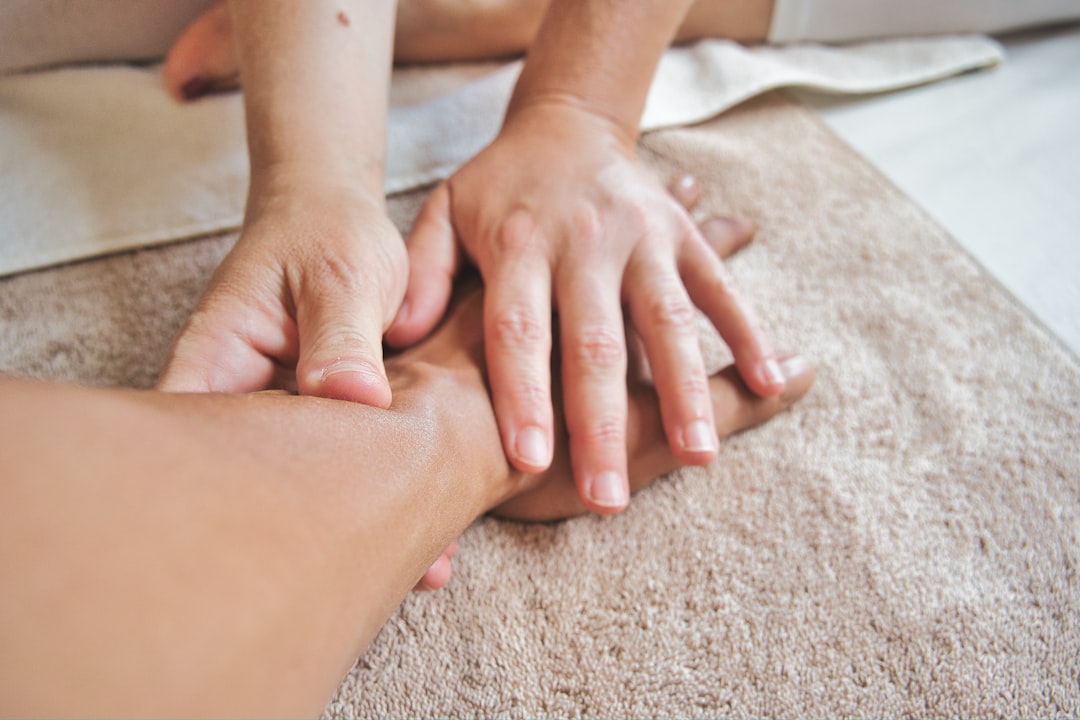 Close-up of hands providing a therapeutic massage on a person's arm